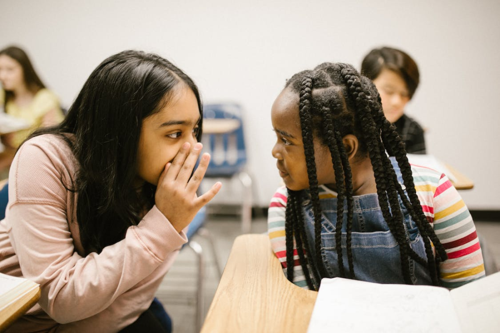 Two girls talking in class.