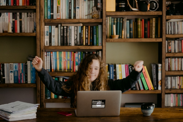 A child is sitting in front of a laptop