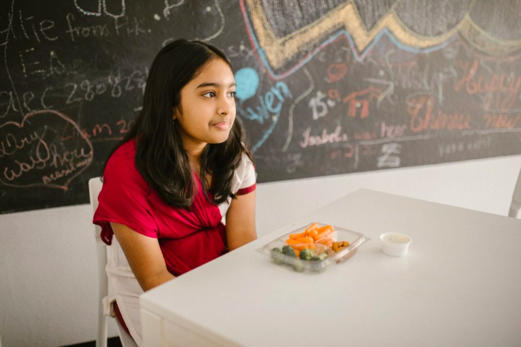 A student enjoys lunch in her classroom at a special needs school.