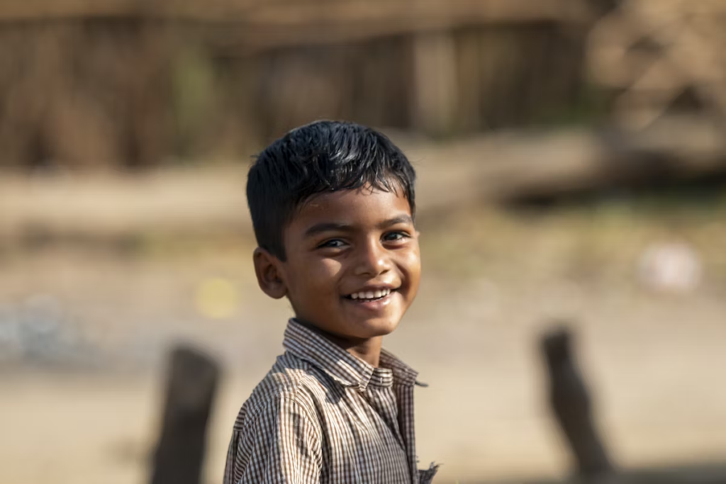 A happy boy smiles at the camera.