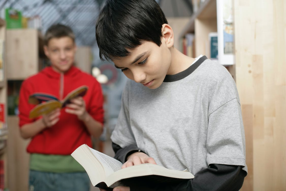 Two boys are holding books.