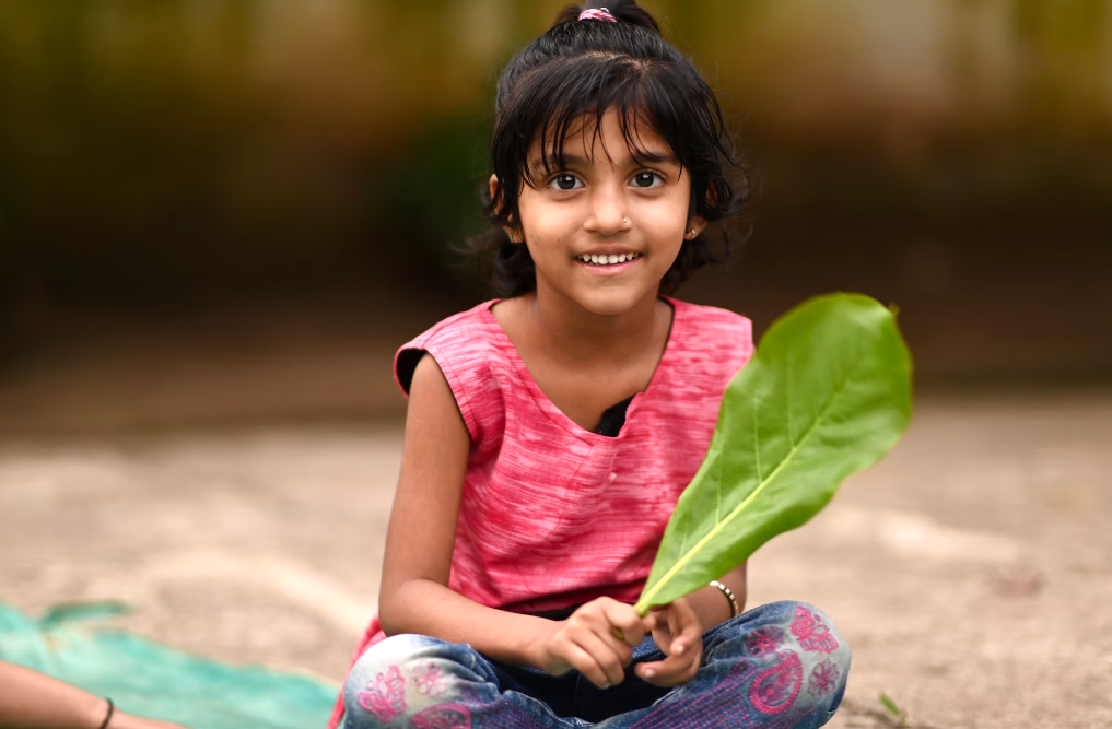 A little girl sitting outdoors. 